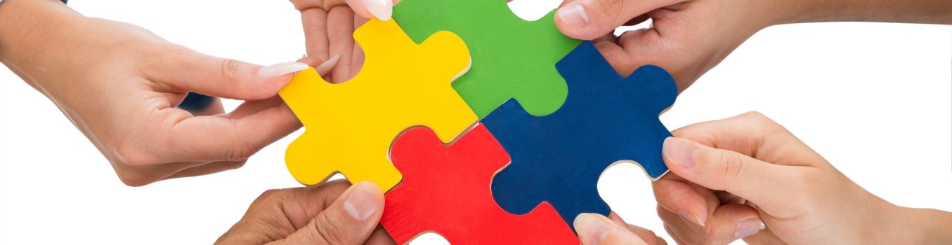 Close-up Of People Hands Connecting Together Jigsaw Pieces